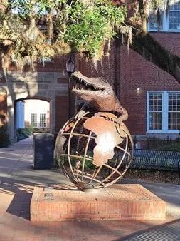 Sculpture d'un alligator posé sur un globe terrestre